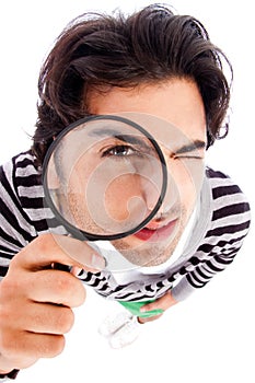 Young man looking up with a magnifying glass photo