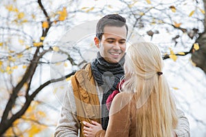 Young man looking at woman in park during autumn