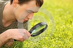 Young man looks through magnifier