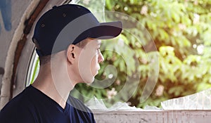 Young man looks into an old broken window