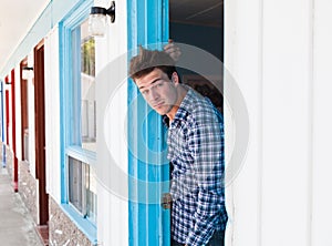 Young man looks out of the motel room