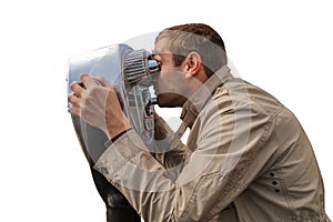 A young man looks through some coin-operated binoculars isolated