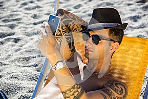 Young man lying on deckchair at beach