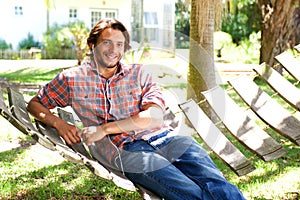 Young man lying in hammock with earphones