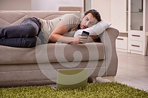 Young man lying on the sofa at home