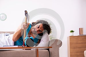 Young man lying on the sofa in time management concept