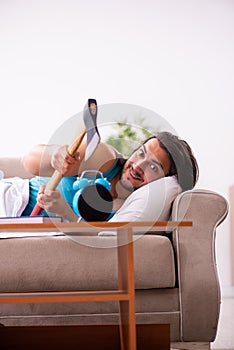 Young man lying on the sofa in time management concept