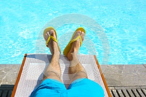 Young man lying on sunbed near pool. Summer vacation and travel photo