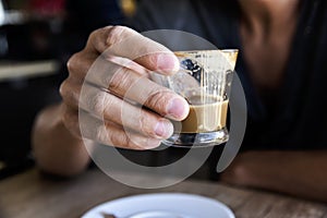 Young man with a macchiato in a coffeehouse photo