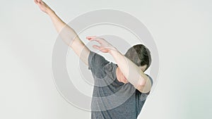 Young man makes a dab or flex it`s dance move on white background