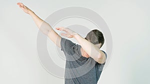 Young man makes a dab or flex it`s dance move on white background