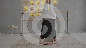 Young man makes a headstand from the back