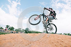 A young man makes tricks on a mountain bike. A cyclist jumps on a bike