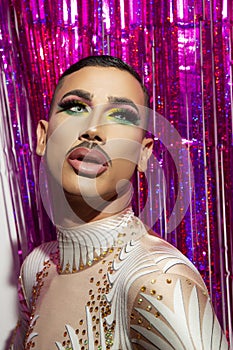 Young man makeup drag queen performer with colorful background