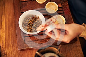 Young man making delicious herbal tea in tea house