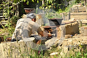 Young man making fire for cooking outside