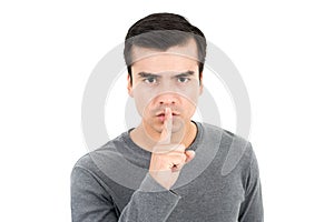 Young man making hush shh gesture