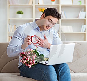 Young man making marriage proposal over internet laptop