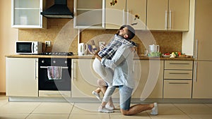 Young man making proposal to his girlfriend in the kitchen at home