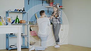 Young man making proposal to his girlfriend in the kitchen at home