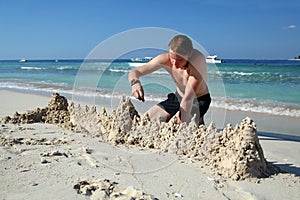 A young man making sand castle