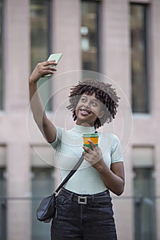 Young man making selfie with mobile phone. Young woman outdoors in the city. Technology and lifestyle concept