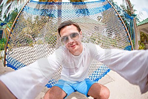 Young man making selfie relaxing at hammock