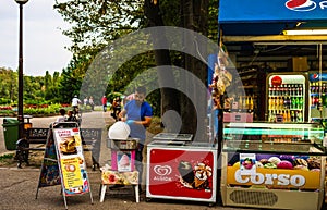 Young man making and selling cotton candy on an alley in the park in Bucharest, Romania, 2019