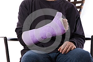 Young man making a thumbs up sign with his casted arm