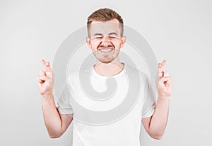 Young man making a wish isolated on white background