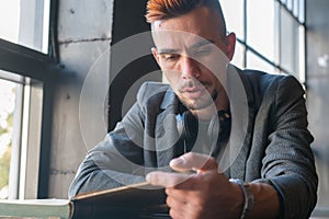 Young man male student hipster reading a book. Knowledge, education, development concept