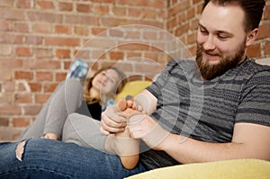 Young man massaging his lover`s feet.