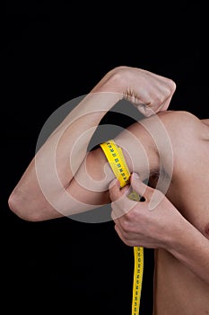 Young man measuring his arm