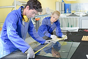 Young man measuring pane glass