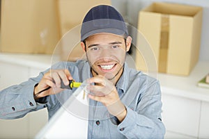 young man measuring width kitchen door during installation