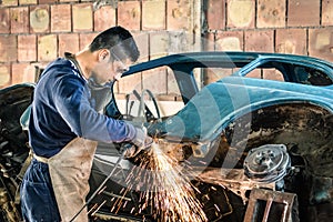 Giovane uomo meccanico lavoratore riparazione vecchio antico auto 