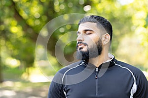 Young man meditating in a tranquil park setting