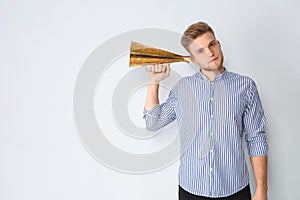 Young man with megaphone on light background