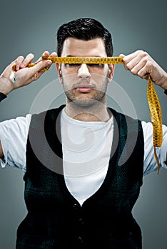 Young Man with a Metre Rule in Front of His Face photo