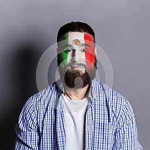 Young man with Mexica flag painted on his face photo