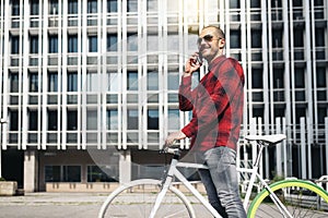 Young man with mobile phone and fixed gear bicycle.