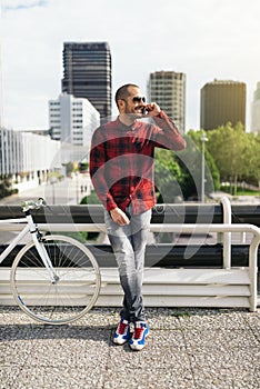 Young man with mobile phone and fixed gear bicycle.