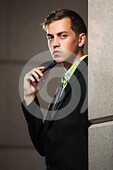 Young man with a mobile phone at the wall