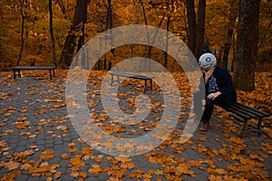 Young man model cosplay posing in costume with funny and slightly creepy head and suit, Halloween eve style photography in vibrant