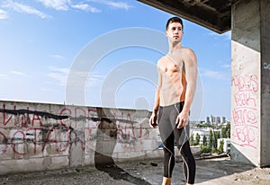 Young man model fit slim muscular model posing outdoors sunny bl