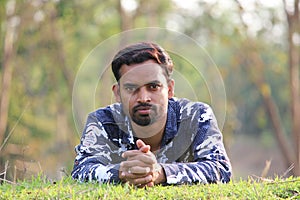 Young man model sleeping on a grass field