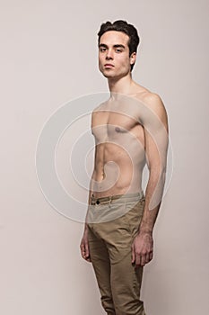 Young man model shirtless body posing pants