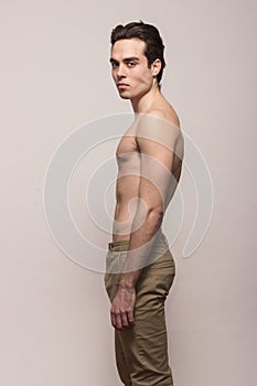 Young man model shirtless body posing pants