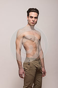 Young man model shirtless body posing pants