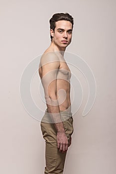 Young man model shirtless body posing pants